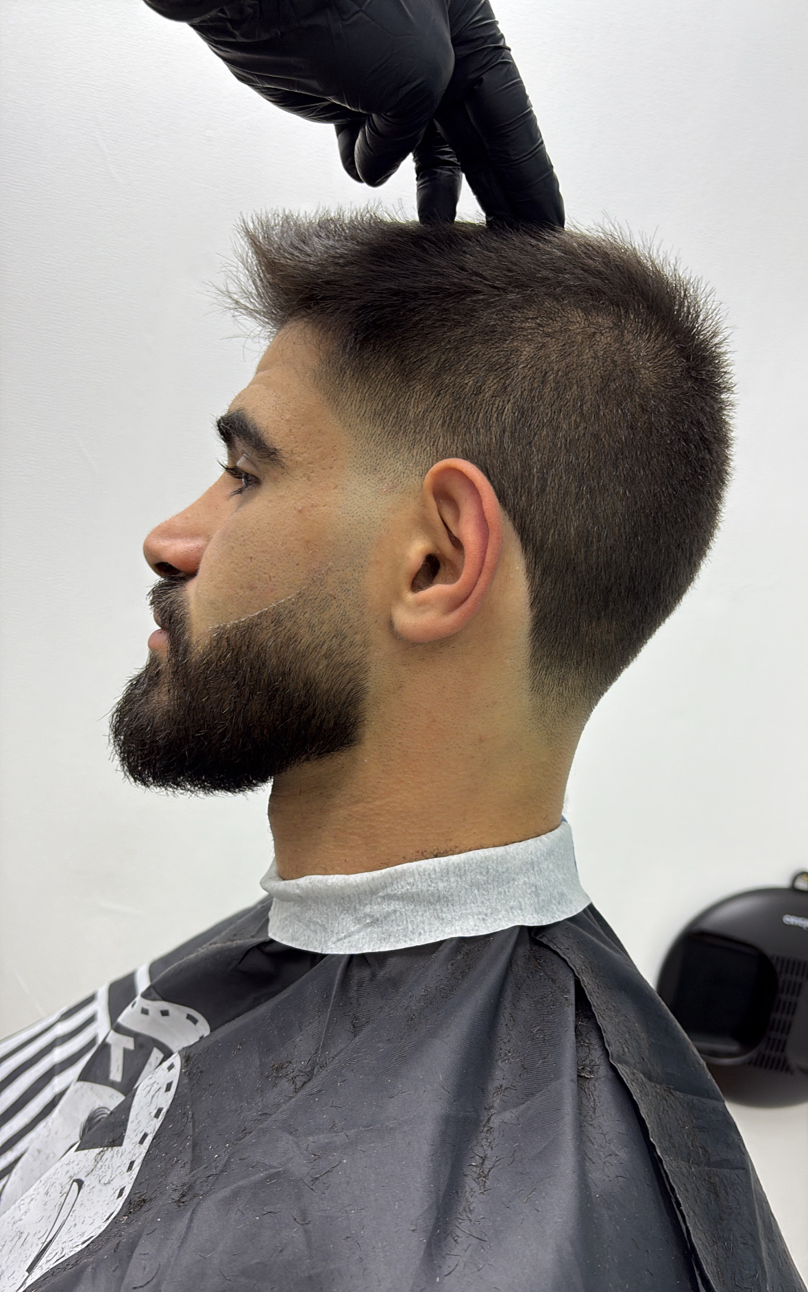Korte fade met volle baard, van opzij gezien